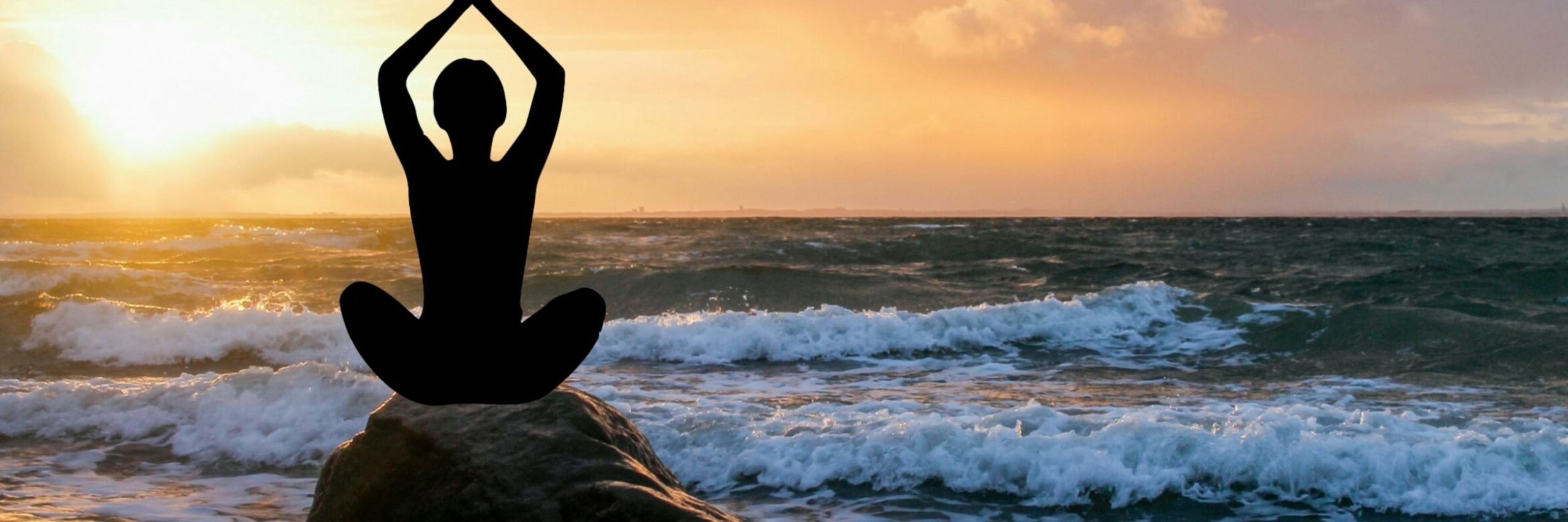 ocean scene with person on a rock, doing a yoga pose